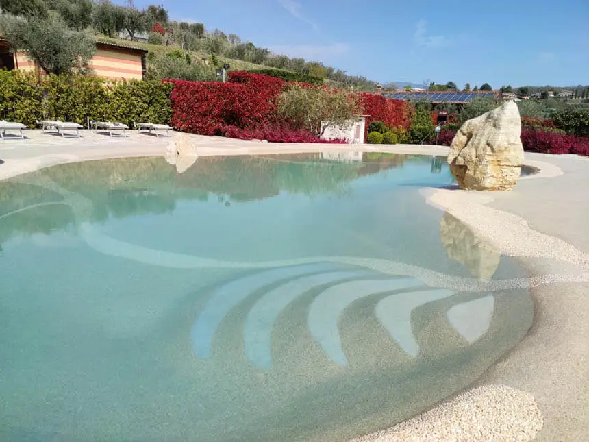 Handcrafted Naturi sand pool with beach entry and natural rock features by Oasis Outdoor Solutions in Huntsville AL